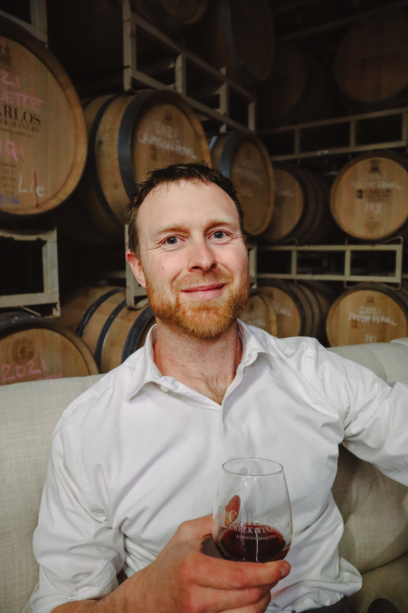 Head Winemaker at Carlos Creek Winery sits with a glass of wine in hand.