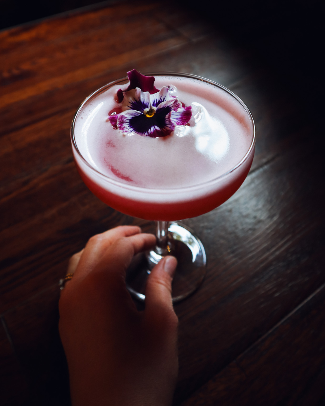 holding a pink petal cocktail